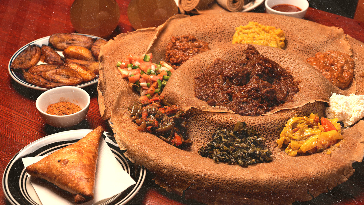 A red table-top with doro wat, plantains, and other Ethiopian small plates at Rosalind’s Restaurant.