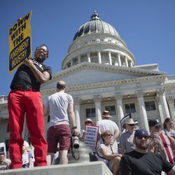 Bradley DeNorris holds a sign at a rally protesting the separation of immigrant children from their parents at the state Capitol in Salt Lake City on Saturday, June 30, 2018.