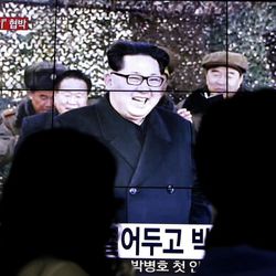 People walk by a TV news program showing North Korean leader Kim Jong Un in Seoul, South Korea, Friday, March 4, 2016. Kim ordered his military on standby for nuclear strikes at any time, state media reported Friday, an escalation in rhetoric targeting rivals Seoul and Washington that may not yet reflect the country's actual nuclear capacity.