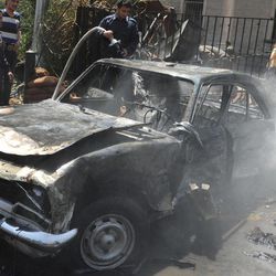 In this photo released by the Syrian official news agency SANA, Syrian firefighters extinguish a burning car, at the scene of a powerful explosion which occurred in the central district of Marjeh, Damascus, Syria, Tuesday April 30, 2013. A powerful explosion rocked Damascus on Tuesday, causing scores of casualties, a day after the country's prime minister narrowly escaped an assassination attempt in the heart of the heavily protected capital. 