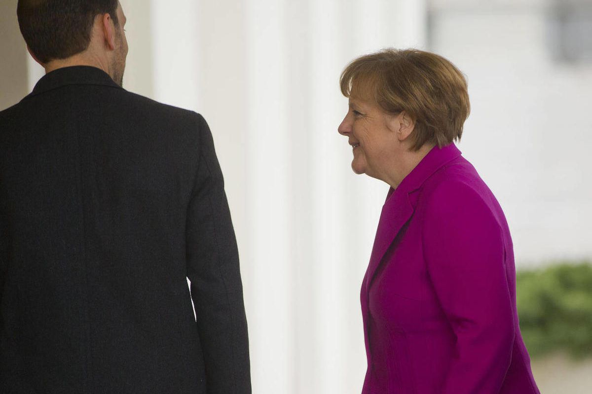 German Chancellor Angela Merkel, right, is greeted by Office of the Chief of Protocol, Ambassador Peter A. Selfridge, left, upon her arrival at the West Wing of the White House in Washington, Monday, Feb. 9, 2015, for her scheduled meeting with President 