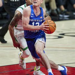 BYU guard Alex Barcello drives to the basket in front of Oregon guard Jacob Young during the second half of an NCAA college basketball game in Portland, Ore., Tuesday, Nov. 16, 2021.