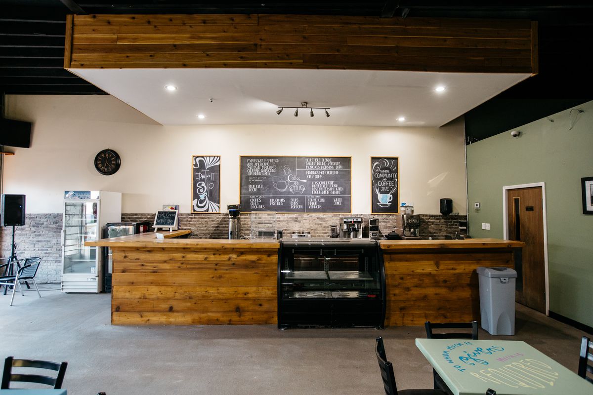 The coffee counter at Detroit sip is paneled with wood and flanked by a light green wall. 