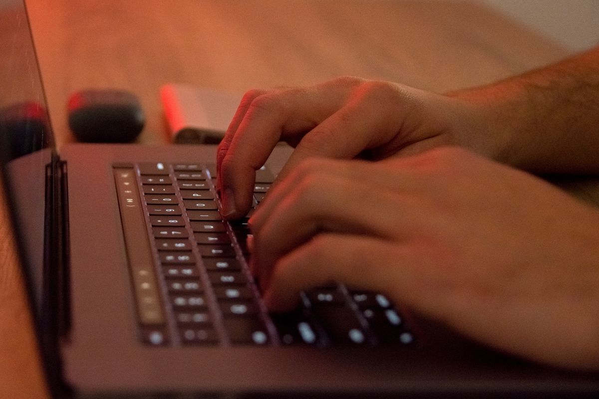 Hands typing on a laptop keyboard.