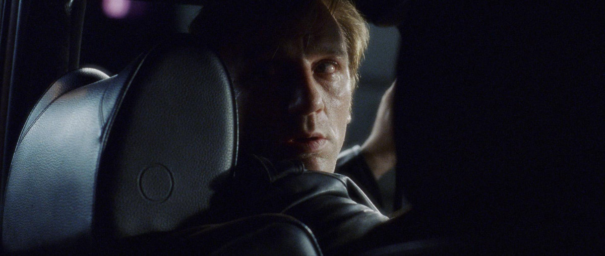 Steve (Daniel Craig) looking over his shoulder in a shadowy car in Munich