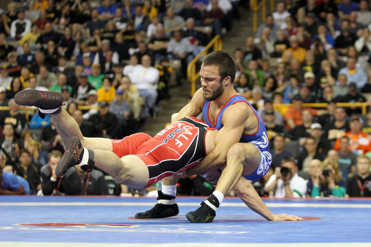 April 22, 2012; Iowa City, IA, USA; Jared Frayer (blue) scores against Brent Metcalf (red) during the 66kg finals freestyle match at Carver Hawkeye Arena.   Mandatory Credit: Reese Strickland-US PRESSWIRE