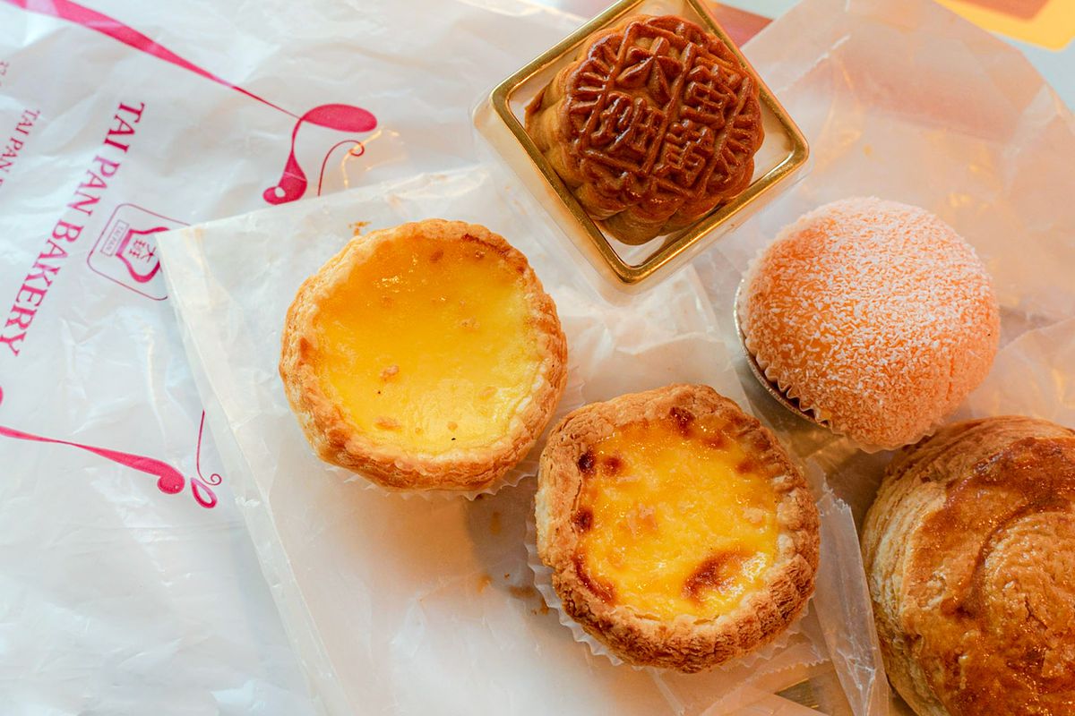 Five Chinese pastries on white plastic bags.