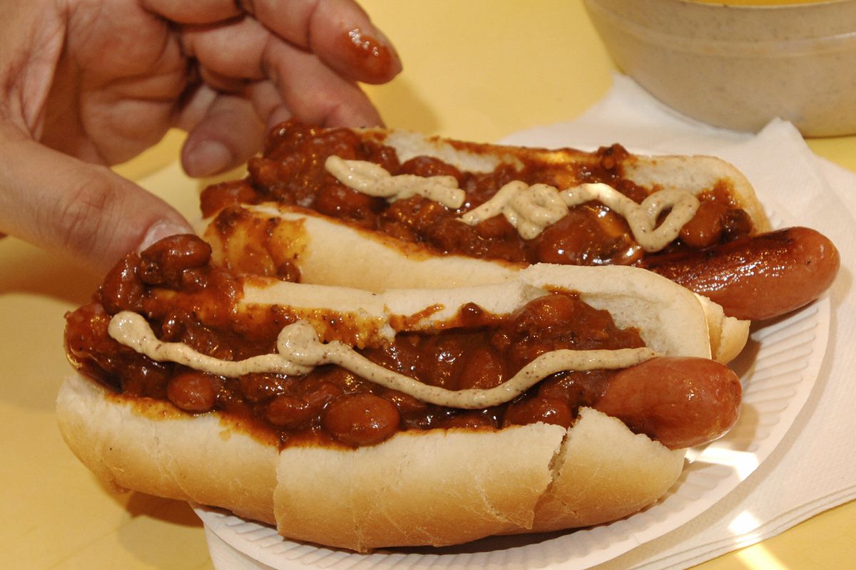 A customer with two hot dogs with chili