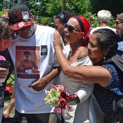 Gerald Wayne Jacobs, of Louisville, is consoled by strangers as he cries at the gates of Cave Hill cemetery in Louisville, Ky., on Friday, June 10, 2016. Jacobs and hundreds of others watched as Muhammad Ali’s funeral procession went by to lay the boxing champ to rest. 