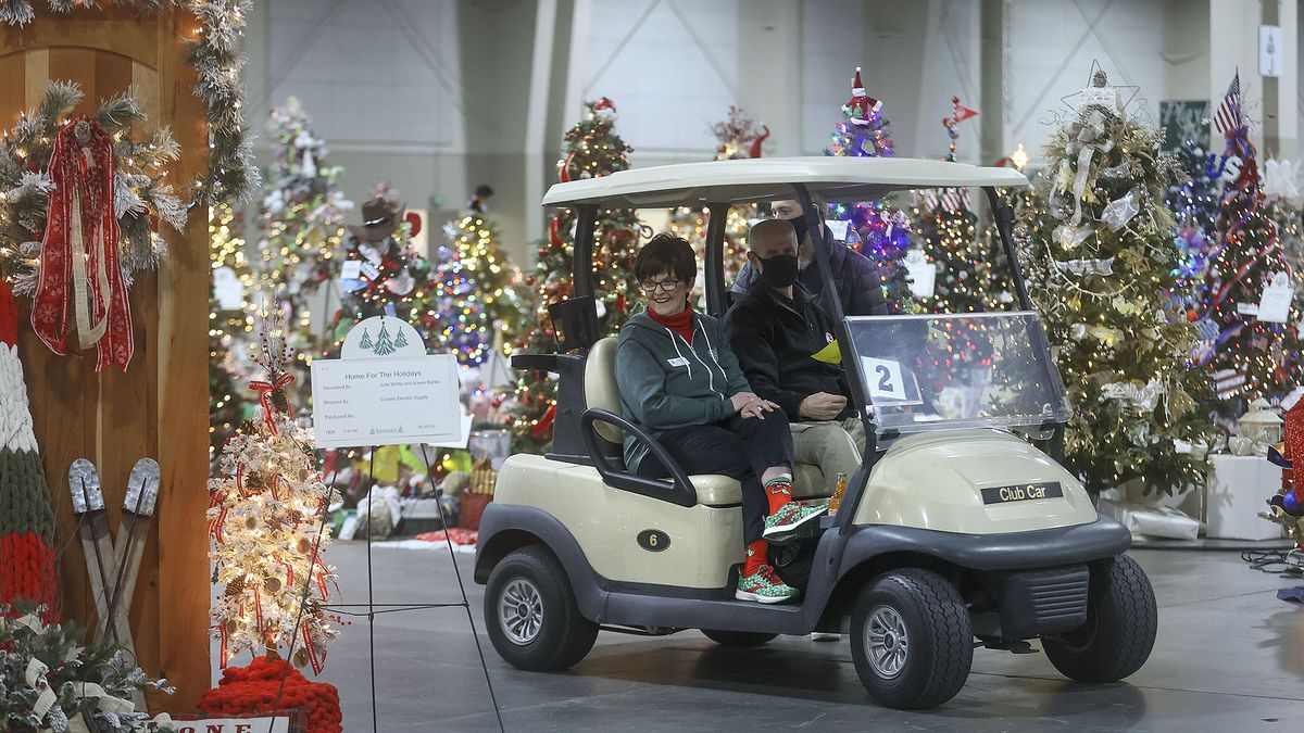 Patti Evershed Peterson and her husband, Clay Peterson, use a golf cart to explore the 51st annual Festival of Trees in Sandy.