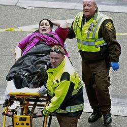 Medical workers aid an injured woman at the finish line of the 2013 Boston Marathon following two explosions there, Monday, April 15, 2013 in Boston. Two bombs exploded near the finish of the Boston Marathon on Monday, killing at least two people, injuring at least 23 others and sending authorities rushing to aid wounded spectators. 