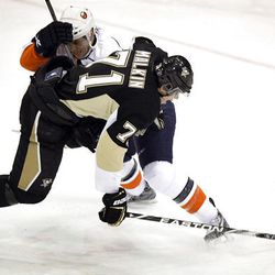Pittsburgh Penguins' Evgeni Malkin, right, of Russia, is checked by New York Islanders' Bruno Gervais as he skates toward the goal in the first period.