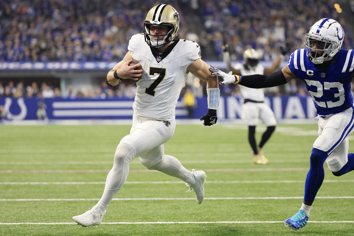 INDIANAPOLIS, INDIANA - OCTOBER 29: Taysom Hill #7 of the New Orleans Saints runs past Kenny Moore II #23 of the Indianapolis Colts while scoring a rushing touchdown during the second quarter at Lucas Oil Stadium on October 29, 2023 in Indianapolis, Indiana.