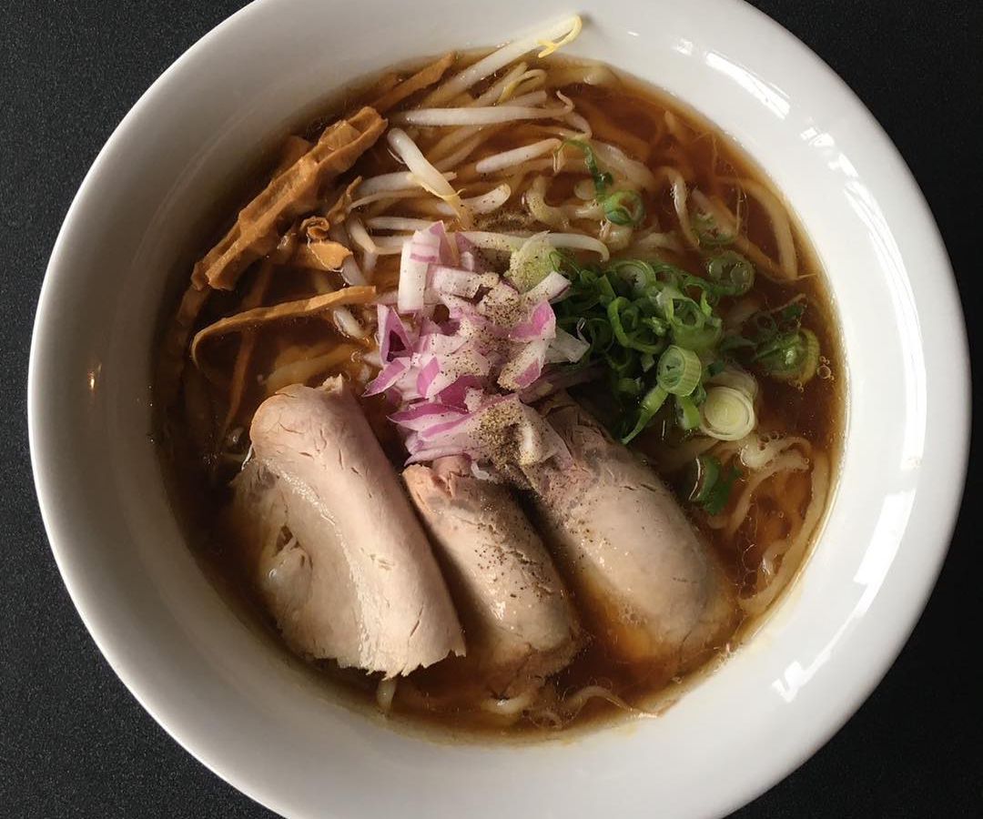 An overhead shot of a bowl of ramen with slabs of pork. 