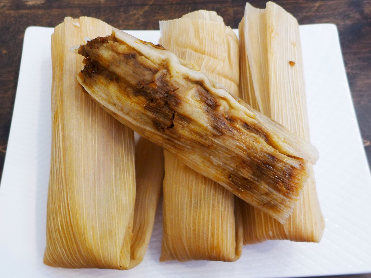 A plate of corn husks stuffed with tamales.