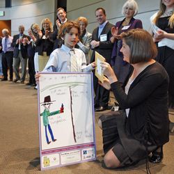 Atticus Teter, 6, from Rowland Hall, wins the prize for the best drawing showing what clothing to wear in the sun, from Dr. Stephanie Klein. Teter was one of 27 finalists for the SunWise with SHADE poster contest, sponsored by the U.S. Environmental Protection Agency. Winners were honored Friday, April 6, 2012, at the Huntsman Cancer Institute.