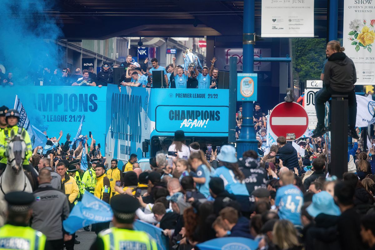 Manchester City players lift the trophy to celebrate winning...