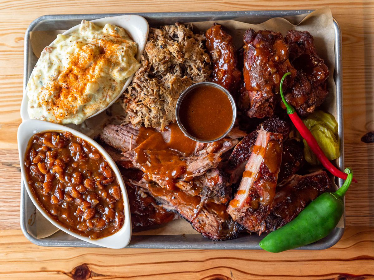 A tray of ribs, brisket, baked beans, and mac and cheese.