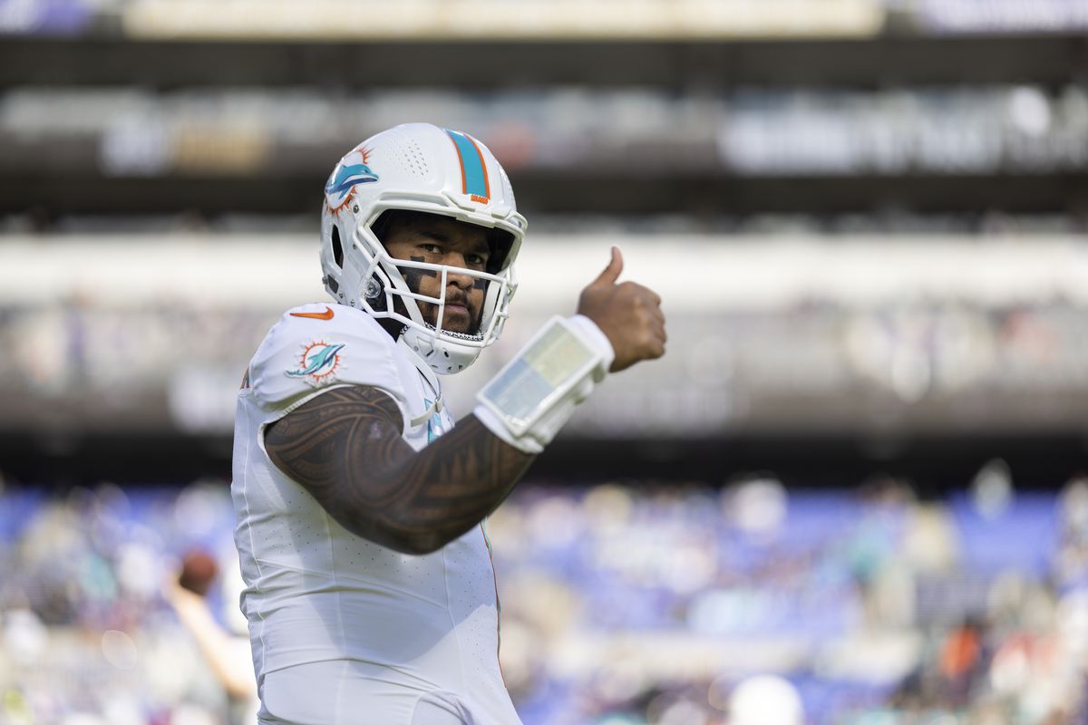Tua Tagovailoa of the Miami Dolphins signals as he warms up prior to an NFL football game between the Baltimore Ravens and the Miami Dolphins at M&amp;T Bank Stadium on December 31, 2023 in Baltimore, Maryland.