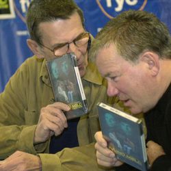Leonard Nimoy, left, and William Shatner talk privately while autographing copies of their recently released DVD/VHS "Mind Meld: Secrets Behind the Voyage of a Lifetime", Sunday, March 17, 2002, in the Century City section of Los Angeles.