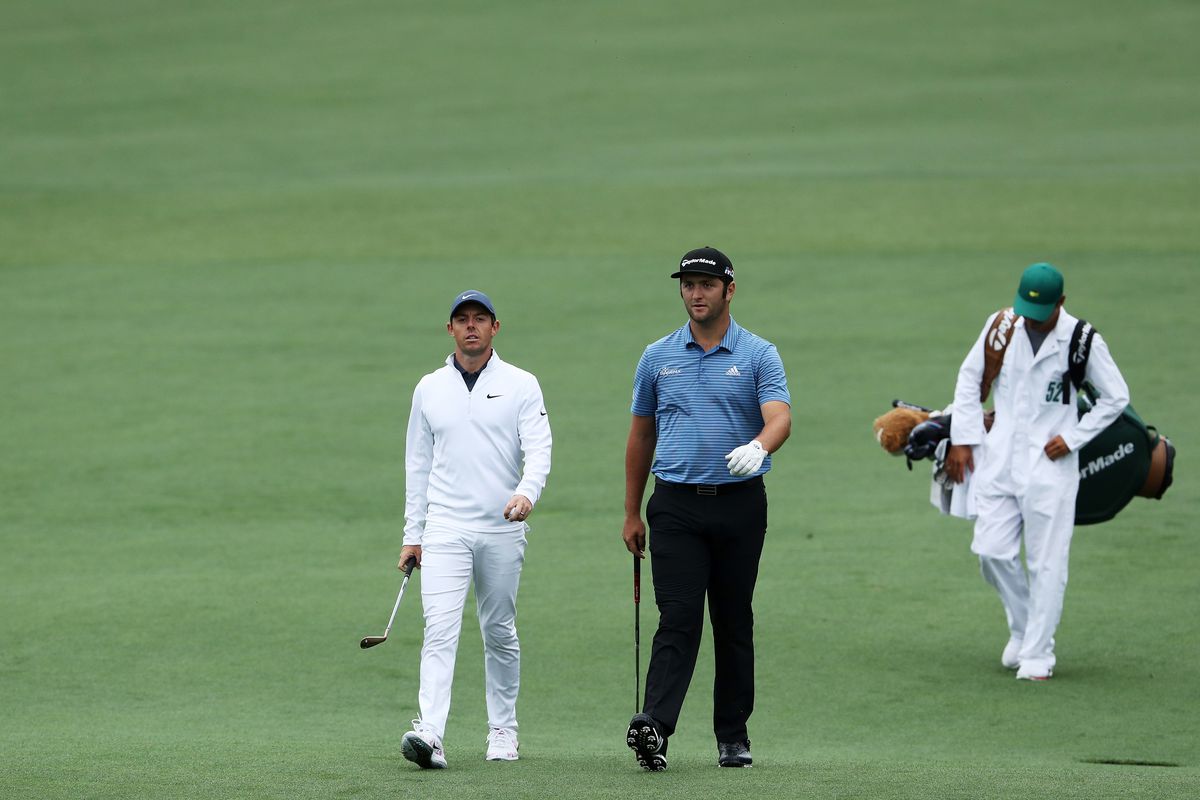 Rory McIlroy of Northern Ireland, Jon Rahm of Spain and caddie Harry Diamond walk together during a practice round prior to the start of the 2018 Masters Tournament at Augusta National Golf Club on April 4, 2018 in Augusta, Georgia.