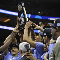 North Carolina players celebrate with the trophy after winning a regional final men's college basketball game against Notre Dame in the NCAA Tournament, Sunday, March 27, 2016, in Philadelphia. North Carolina won 88-74 to advance to the Final Four. (AP Photo/Chris Szagola)