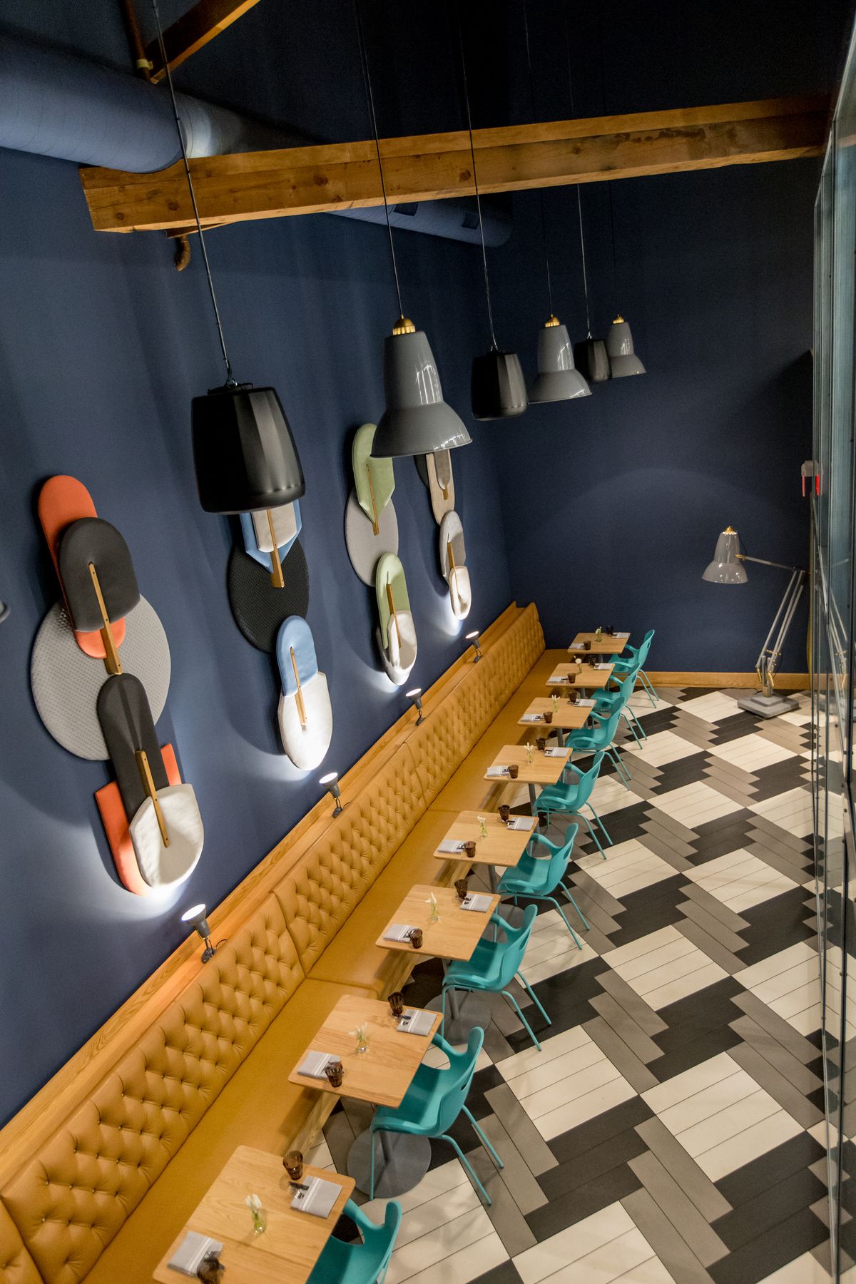 A picture of Enoteca Nostrana’s back room, which uses colorful, abstract pizza paddles as decoration