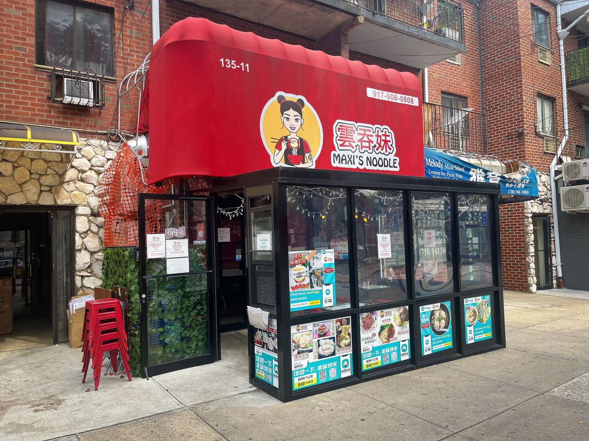 A red awning features a woman eating noodles and letters that read “Maxi’s Noodle.”