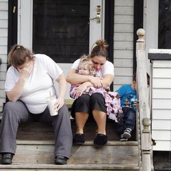 Neighbors sit outside the house of Krystle Campbell's parents in Medford, Mass.,Tuesday, April 16, 2013. Campbell was killed in Monday's explosions at the finish line of the Boston Marathon. 