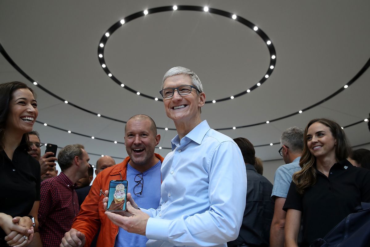 Apple designer Jony Ive and CEO Tim Cook hold the new iPhone X at the launch event.