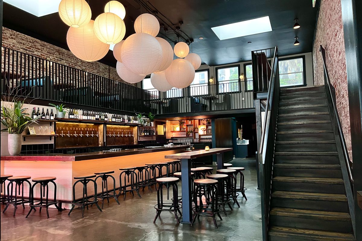 Inside Key Klub, a bar with brick walls and modern round light fixtures.