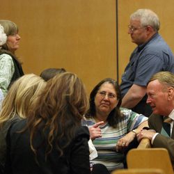 Judy Cox, center, and Chuck Cox, standing, talk with family and friends during a break in the Steven Powell trial in Pierce County Superior Court in Tacoma, Wash., Tuesday, May 15, 2012. Judy and Chuck are the parents of Susan Powell.