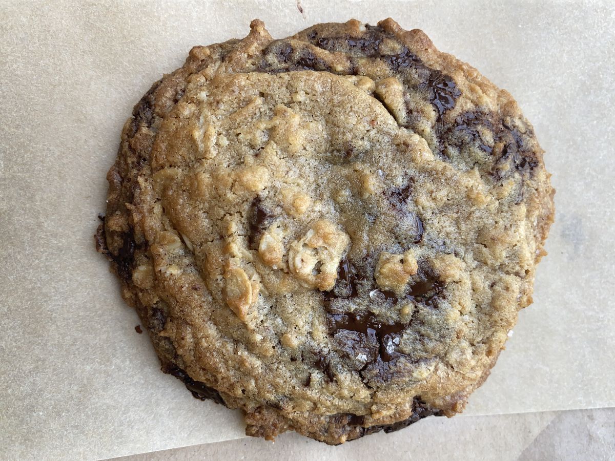 A chocolate chip cookie on brown greaseproof paper.