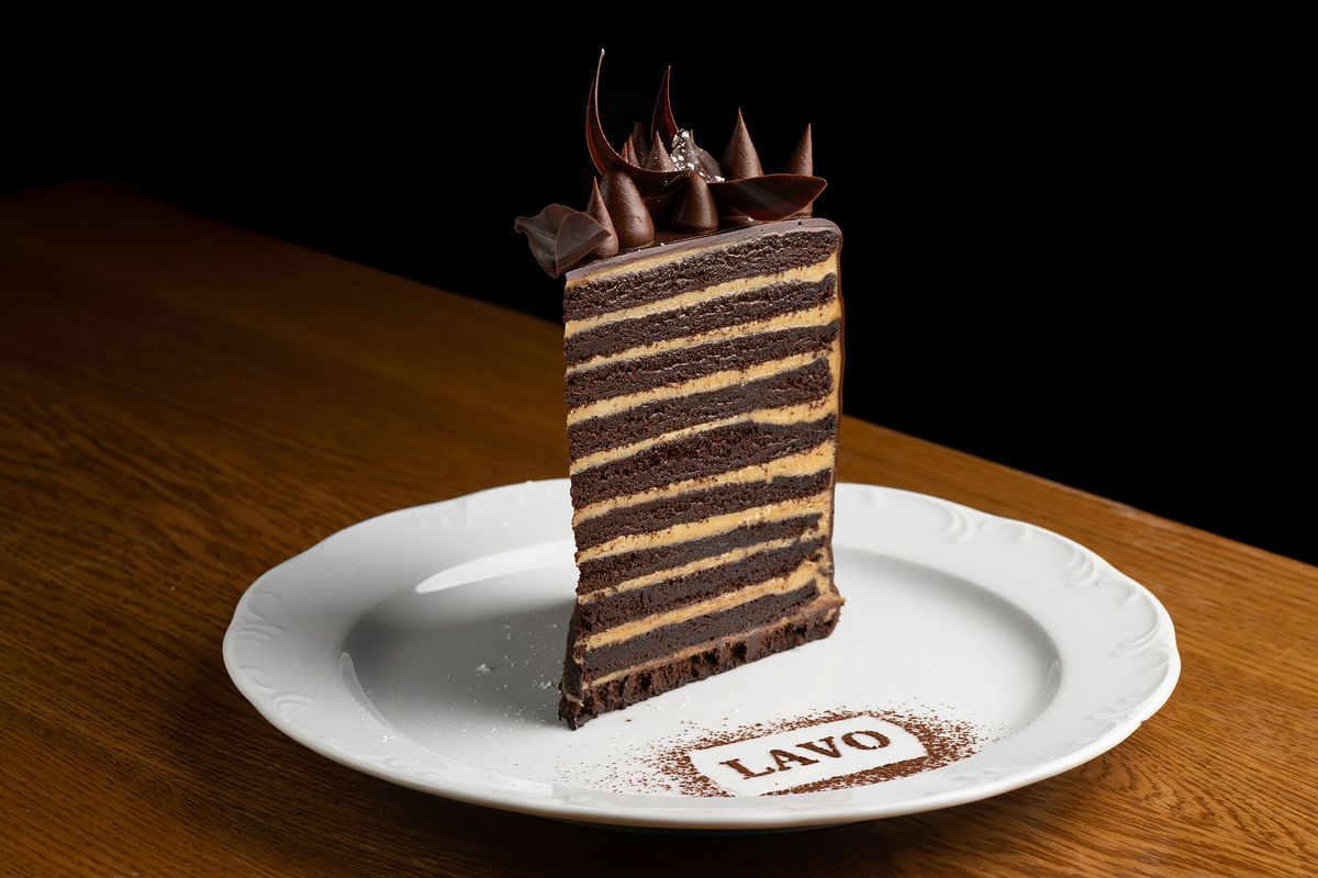 A tall tiered cake with frosting and a sign reading Lavo.