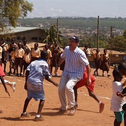 Steve Young participates in a game of soccer with children in Ghana.
