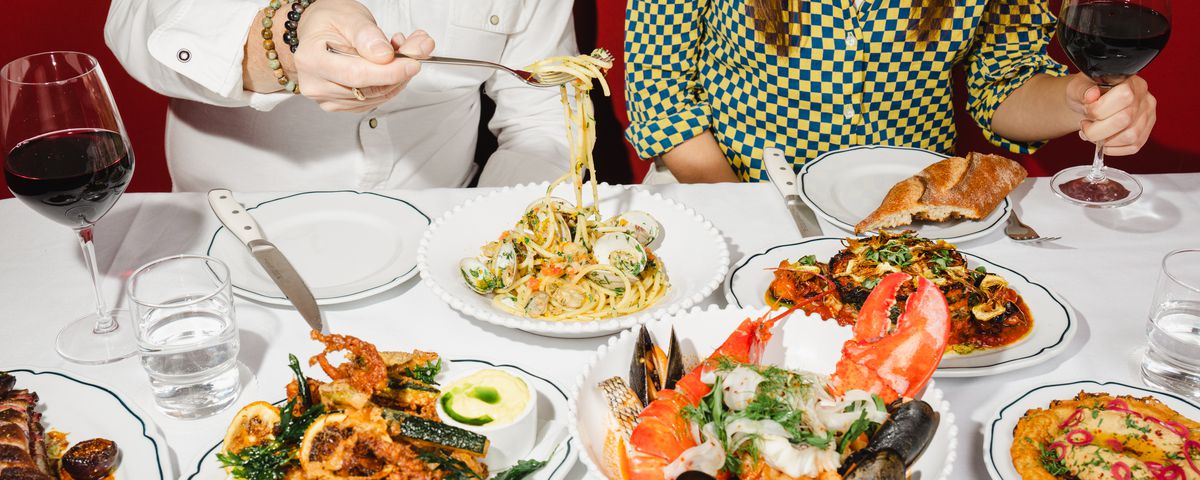 A white tablecloth table filled with seafood dishes.