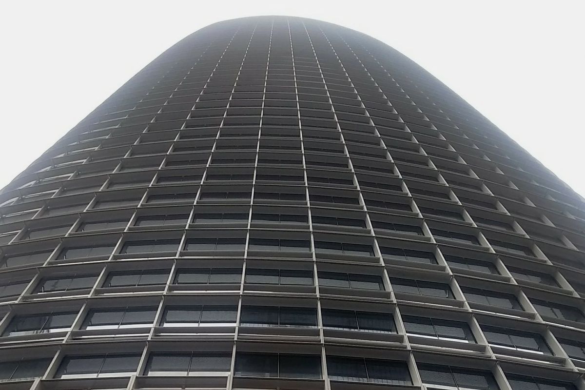A photo from the bottom of Salesforce Tower, looking up to the top, shrouded in fog.