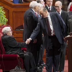 President Thomas S. Monson shakes hands with President Boyd K. Packer as he and his Counselors Henry B. Eyring and Dieter F. Uchtdorf walk onto the stand prior to the start of the morning session of 183 annual General Conference of the Church of Jesus Christ of Latter Day Saints Saturday, April 6, 2013 inside the Conference Center.