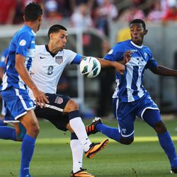 Clint Dempsey (8) of the U.S. tries to get a kick off with Honduras' Jose Valasquez (5) and a teammate defending as the United States and Honduras play Tuesday, June 18, 2013 at Rio Tinto Stadium. USA beat Honduras 1-0.
