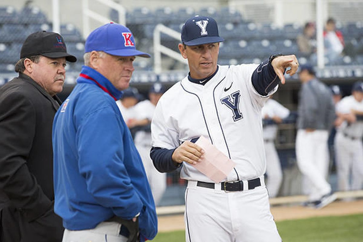 Mike Littlewood (right) talks to the umpire and opposing coach before a game in 2014.