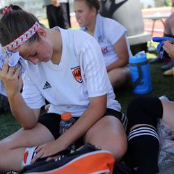 Hannah Christensen holds a towel that's been soaking in ice water against her head to keep cool while taking a break from playing soccer during the University of Utah High School Match Camp in Salt Lake City on Monday, June 20, 2016.