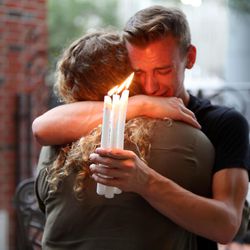 FILE - In this Sunday, June 12, 2016 file photo, Brett Morian hugs an fellow mourner during a candlelight vigil for those killed at the Pulse nightclub in Orlando, Fla. The worst mass shooting in modern U.S. history unfolded on Latin Night at the gay nightclub. The gunman, Omar Mateen, killed 49 people over the course of three hours before dying in a shootout with SWAT team members. During the standoff, he pledged allegiance to the Islamic State.