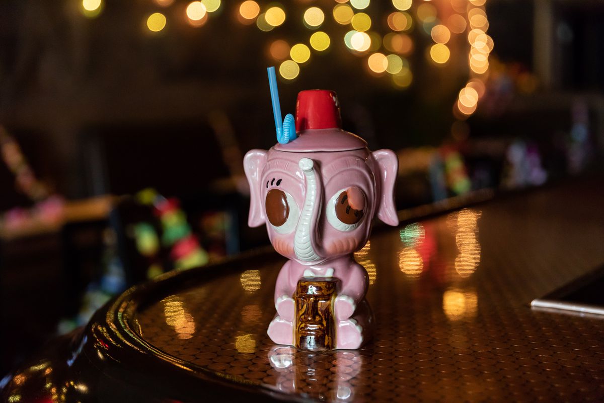 A tiki cocktail served in a pink elephant mug.