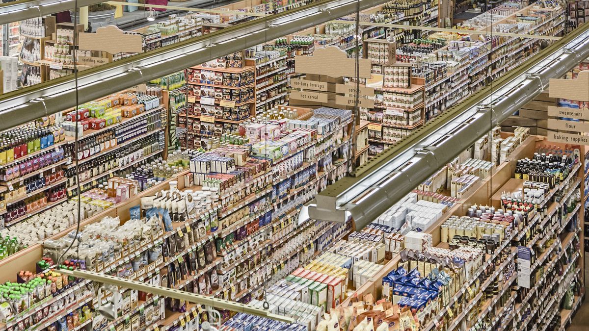 Aisles in a well-stocked grocery store, shot from above.