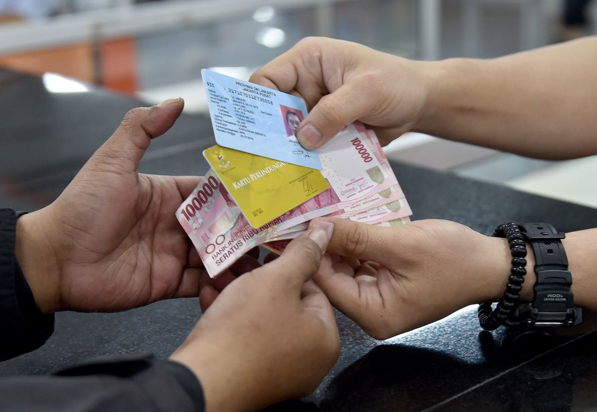 A man receives a cash transfer in Jakarta, Indonesia.