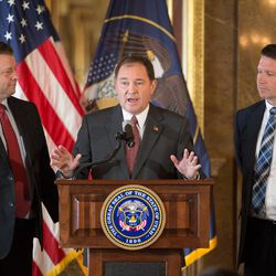 Sen. Todd Weiler, R-Woods Cross, left, and Rep. Val Peterson, R-Orem, left, join Gov. Gary Herbert, center, at the podium after Herbert signed HB127, which adds the "In God We Trust" license plate to the standard options available, at the Capitol in Salt Lake City on Monday, March 21, 2016. Herbert also endorsed GOP presidential candidate Ted Cruz. 