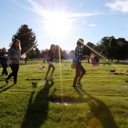 Sandy area youths place American flags at the graves of veterans at the Larkin Sunset Gardens Cemetery in Sandy on Thursday, May 26, 2016.