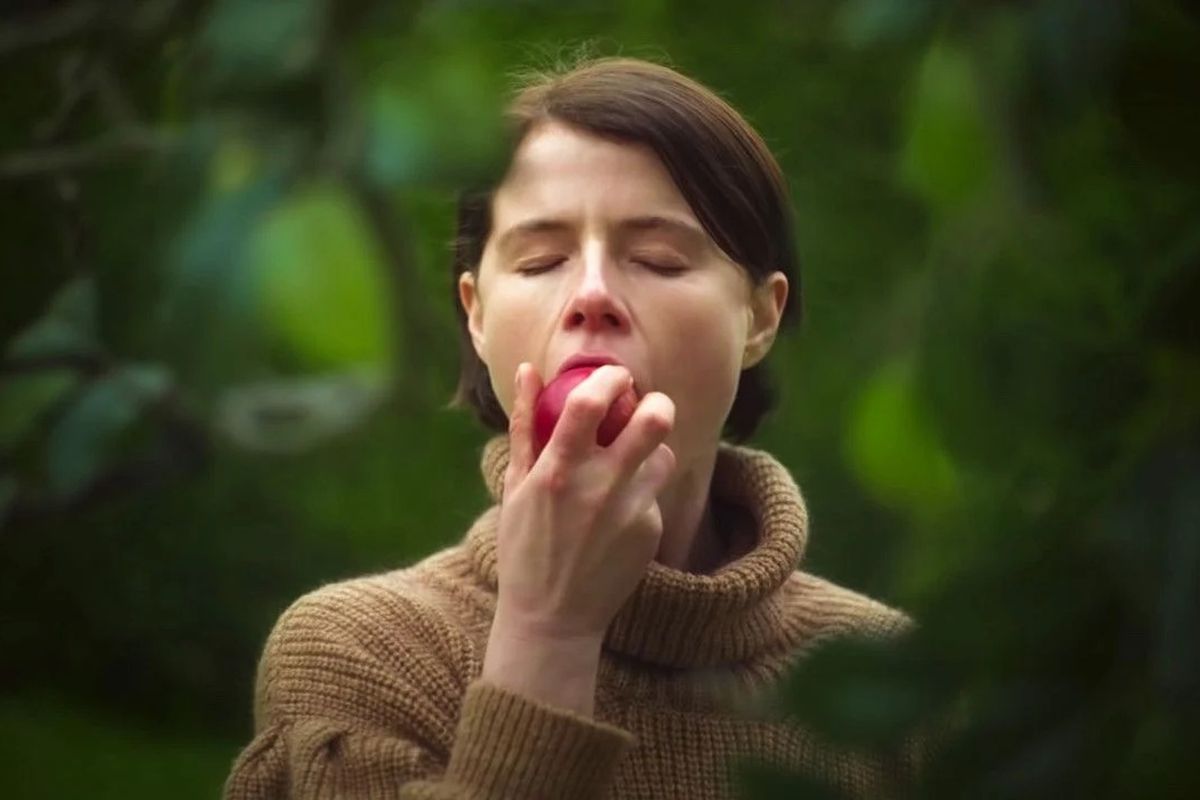Jessie Buckley bites into an apple.