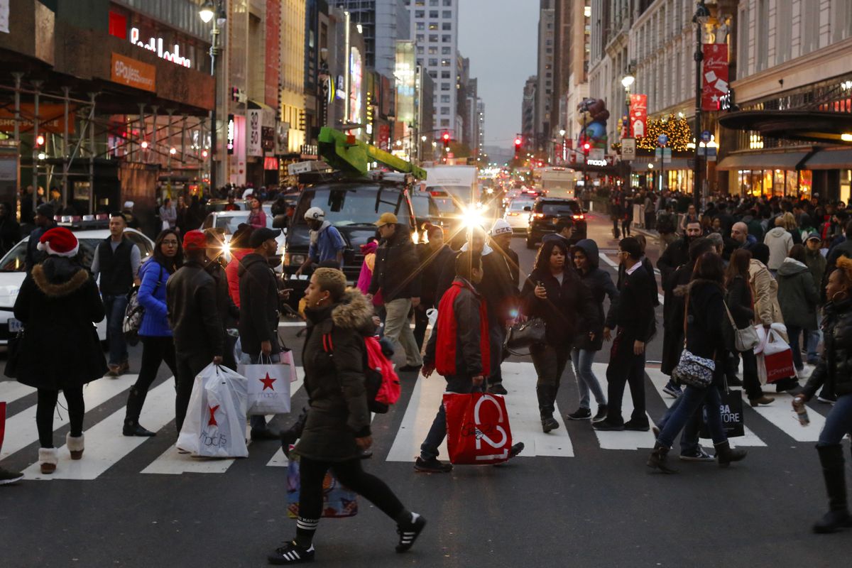 People walking with shopping bags outside of Macy's in NYC