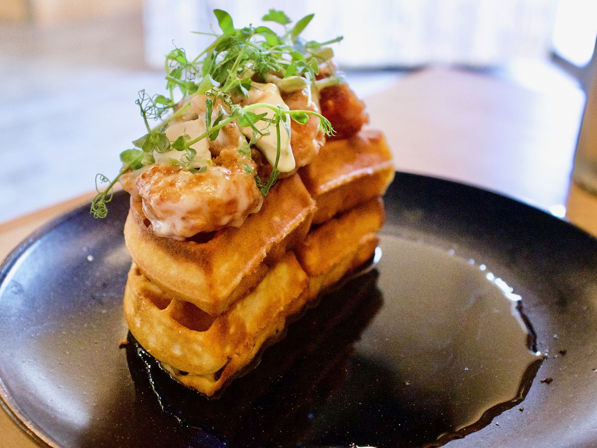 Glazed shrimp and greens top a double stack of waffles. 